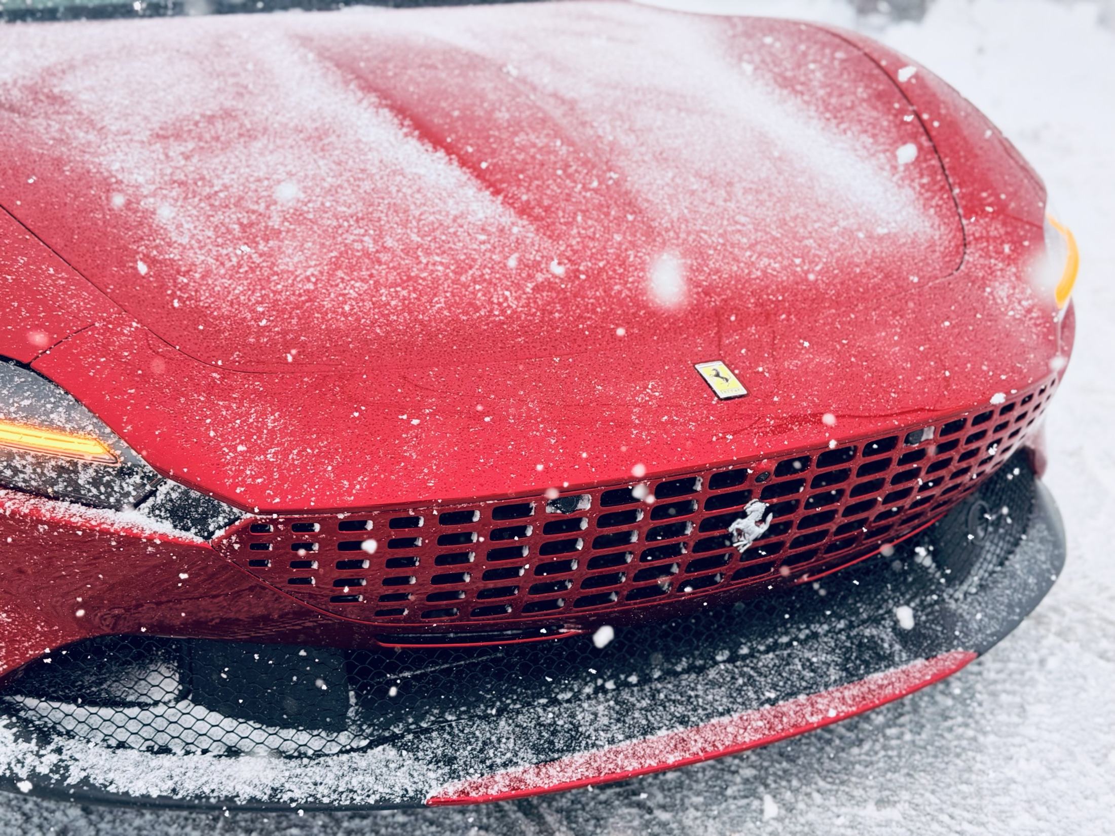 Red performance car with water beading on protective film